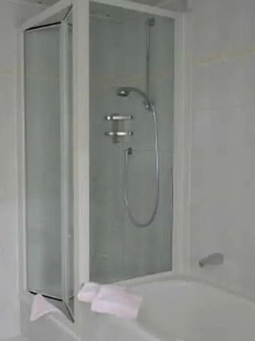 Modernes Badezimmer mit Badewanne und Duschwand