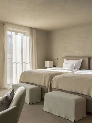 Elegantes Doppelzimmer mit modernen Möbeln und großen Fenstern