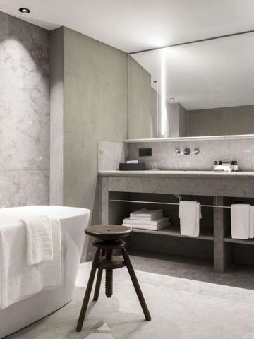 Modernes Badezimmer mit freistehender Badewanne und großem Spiegel