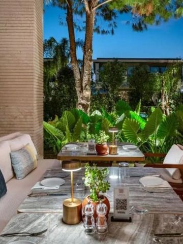 Atmosphärische Außenterrasse mit Blick auf tropische Bepflanzung