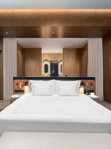 Luxuriöses Schlafzimmer mit Kingsize-Bett und elegantem Holzwanddesign