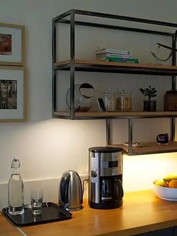 Kompakte Küchenzeile mit Regalen und Kaffeemaschine