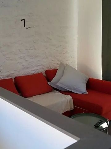 Gemütliche Sitzecke mit rotem Sofa und dekorativer Wand