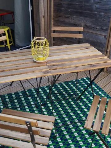 Holzmöbel und bunte Tischdecke auf Terrasse