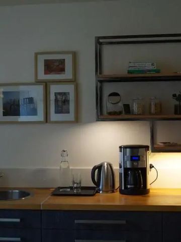 Moderne Küche mit Holzarbeitsplatte und Kunstwerken an der Wand