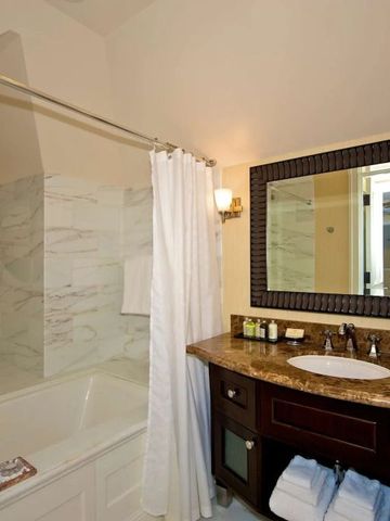 Badezimmer mit Badewanne Duschvorhang und Waschbereich