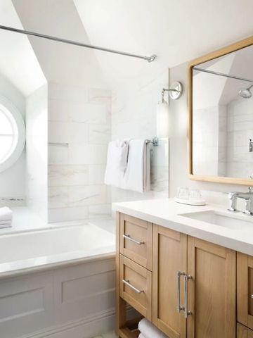 Modernes Badezimmer mit heller Einrichtung und rundem Fenster