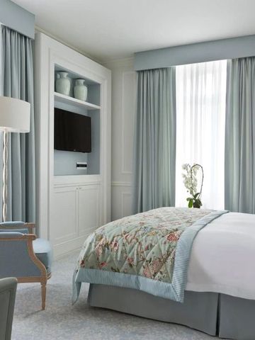 Elegantes Hotelzimmer mit Tageslicht und blauen Vorhängen