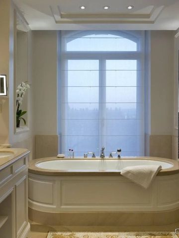 Elegantes Badezimmer mit freistehender Badewanne und großem Fenster