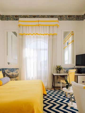 Helles Hotelzimmer mit gelben und blauen Akzenten und Tageslicht