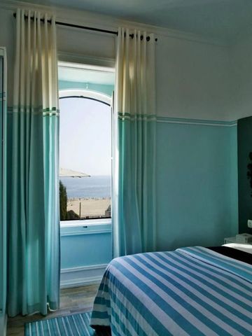 Helles Zimmer mit Seeblick und blauen Akzenten sowie geräumiger Fensterfront