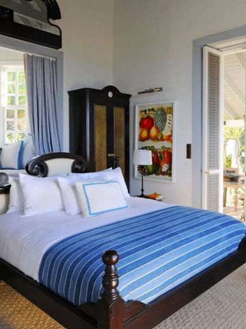 Gemütliches Schlafzimmer mit gestreifter Bettdecke und einladender Veranda