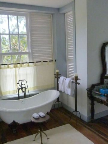 Elegantes Badezimmer mit freistehender Badewanne und antikem Schminktisch