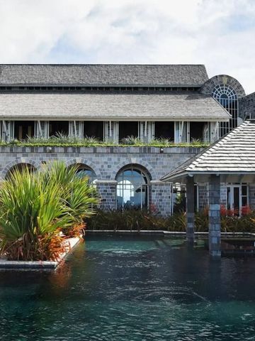 Resort-Hauptgebäude mit wunderschöner Poollandschaft und tropischen Pflanzen