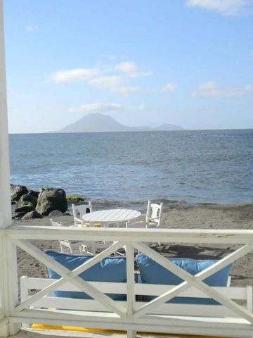 Ausblick von Terrasse auf Strand und Meer mit Vulkan im Hintergrund