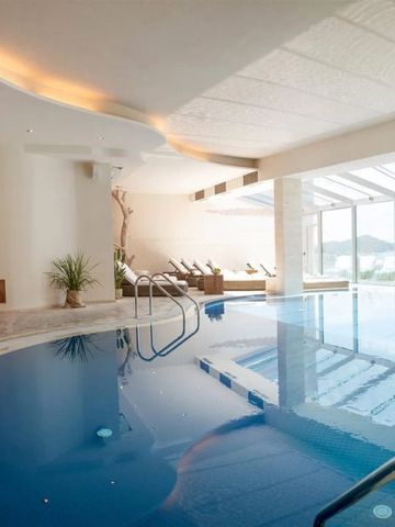 Moderner Innenpool mit Liegestühlen und großen Fenstern