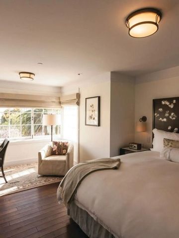 Lichtdurchflutetes Schlafzimmer mit elegantem Doppelbett und Sitzecke im El Encanto Santa Barbara