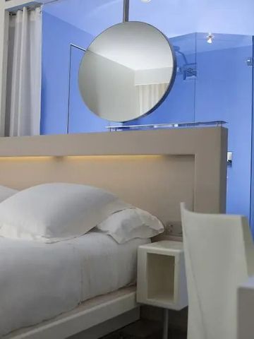 Detailaufnahme eines Bettes mit blauer Badezimmerwand im Hintergrund
