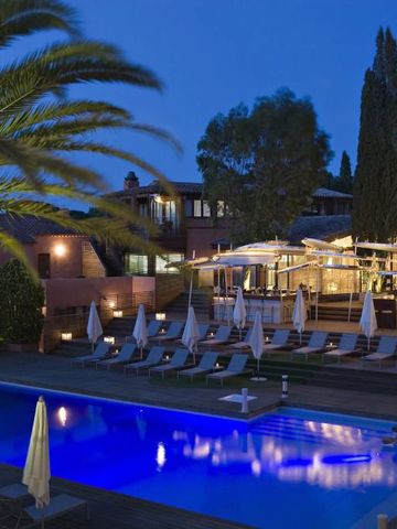 Pool mit Liegestühlen und Palmen bei Abenddämmerung