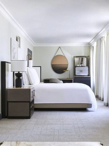 Modernes Schlafzimmer im Beverly Wilshire mit stilvollem Dekor und großem Fenster.