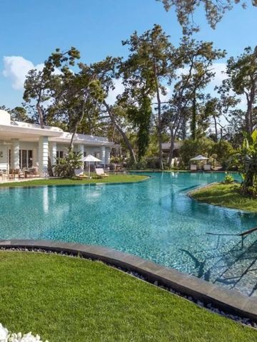 Großer Außenpool mit umliegender grüner Landschaft und blühenden Gärten