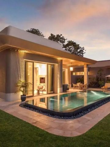 Moderne Villa mit beleuchtetem Pool und Lounge-Bereich bei Sonnenuntergang