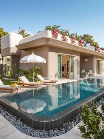 Luxusvilla mit Infinity-Pool und Liegestühlen im Garten