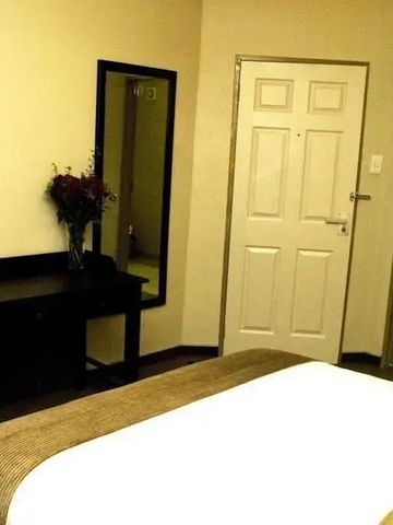 Schlafzimmer mit Doppelbett, Spiegel und Nachttischlampe