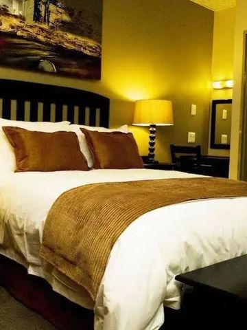 Modernes Schlafzimmer mit großem Bett, dekorativer Kunst an der Wand