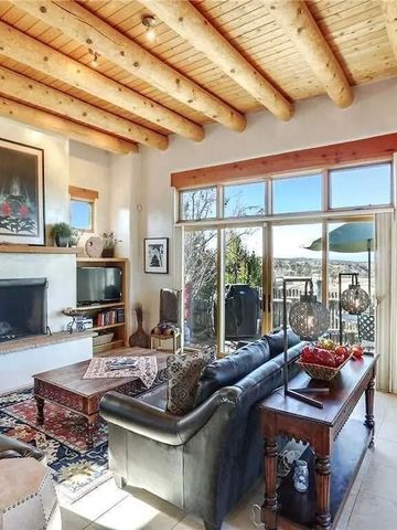 Helles Wohnzimmer mit großen Fenstern und gemütlichem Sofa.