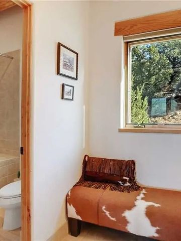 Gemütliche Sitzecke mit Naturblick durch das Fenster im Badezimmerbereich.