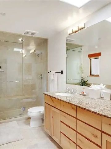 Modernes Badezimmer mit großer Glasdusche und Doppelwaschbecken.