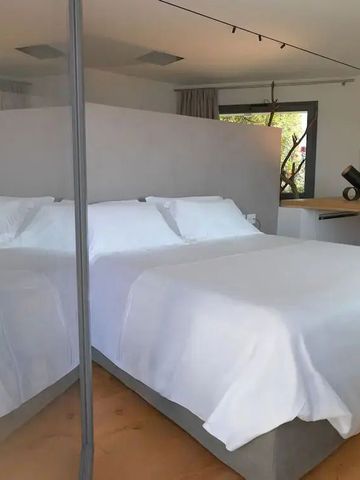 Helles Schlafzimmer mit großem Bett und Glasabtrennung