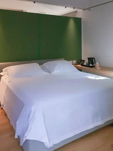 Modernes Schlafzimmer mit grünem Wandakzent