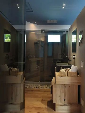 Luxuriöses Badezimmer mit Glaswänden und natürlichen Holzelementen