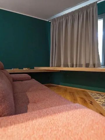 Gemütliche Sitzecke mit rosa Polstermöbeln und Holzarbeiten