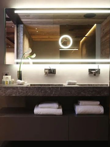 Modernes Badezimmer mit Doppelwaschbecken und beleuchtetem Spiegel