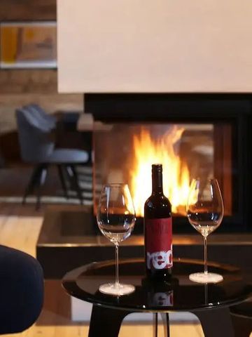 Gemütlicher Raum mit Kamin und Wein, stilvolle Atmosphäre