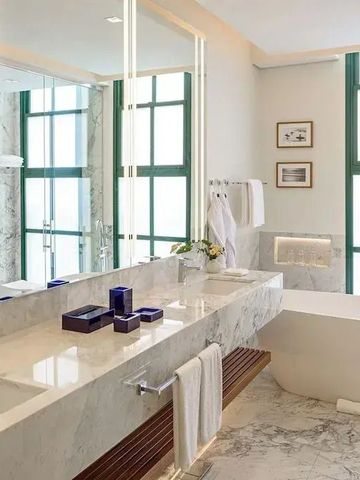 Marmorbadezimmer mit Doppelwaschbecken und freistehender Badewanne