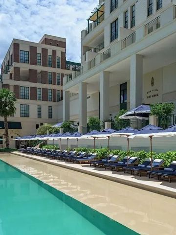 Großer Swimmingpool im Freien mit bequemen Liegestühlen und Sonnenschirmen