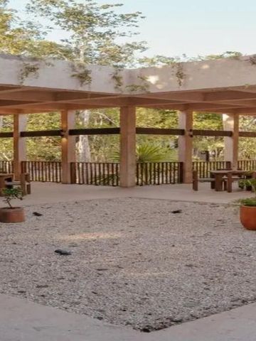 Offene Terrasse mit Holzbalken umgeben von Natur