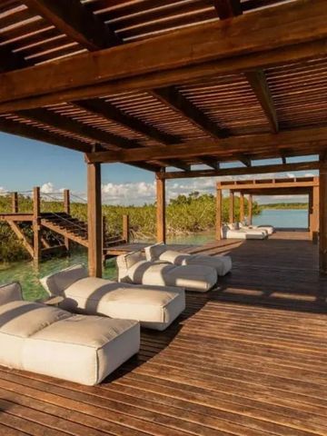 Holzsteg mit Liegen über Wasser mit Panoramablick