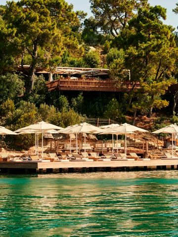 Sonnenschirme und Liegen am ruhigen Wasser