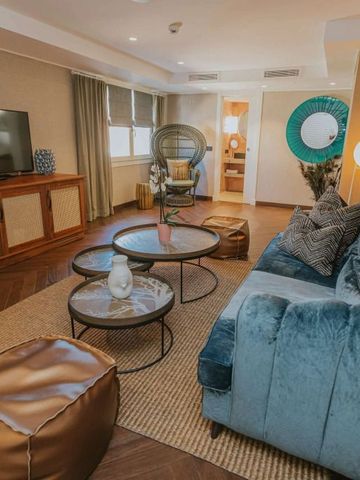 Großzügige Lounge mit blauer Samtcouch und elegantem Dekor