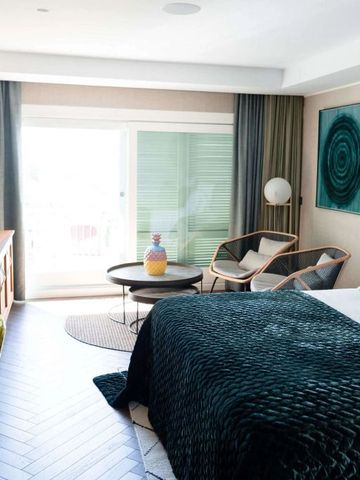 Modernes Zimmer mit gemütlicher Sitzecke und Balkonzugang