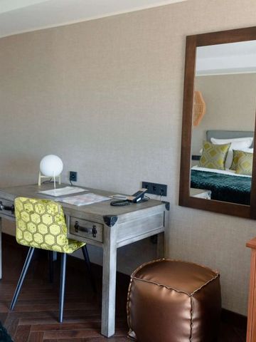 Arbeitsbereich im Hotelzimmer mit stilvollem Schreibtisch und Spiegel