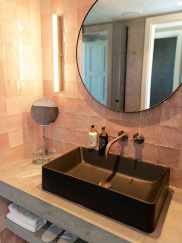 Modernes Bad mit rundem Spiegel und stilvollem Waschbecken in schwarzem Finish