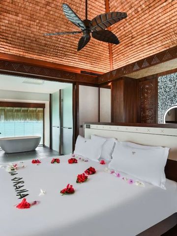 Geräumiges Schlafzimmer mit Himmelbett und moderner Badewanne