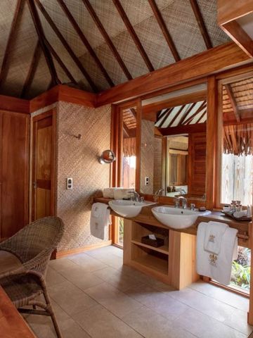 Holzverkleidetes Badezimmer mit Doppelwaschbecken und Spiegel