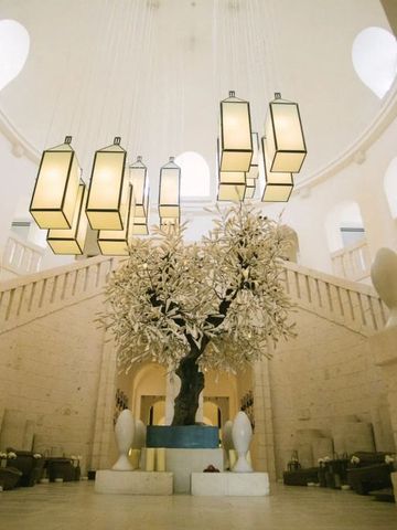 Elegante Empfangshalle mit kunstvollen Leuchten und dekorativem Baum im Borgo Egnazia